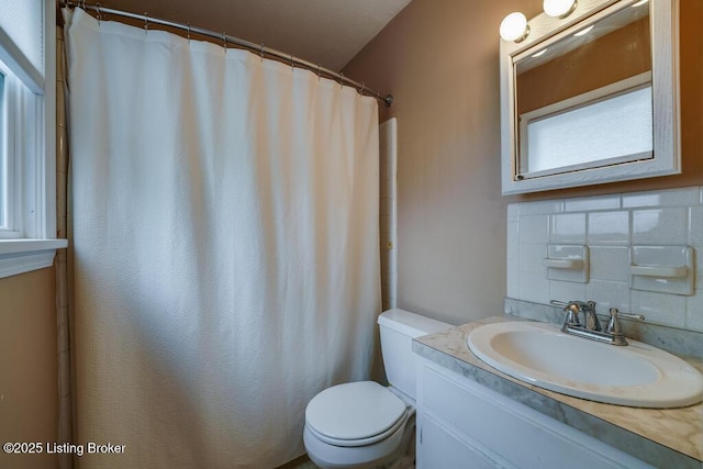bathroom featuring vanity, toilet, a shower with curtain, and tasteful backsplash