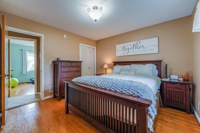 bedroom featuring a closet, light wood-style flooring, baseboards, and visible vents