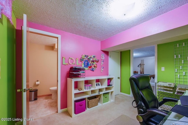 carpeted home office featuring a textured ceiling and baseboards