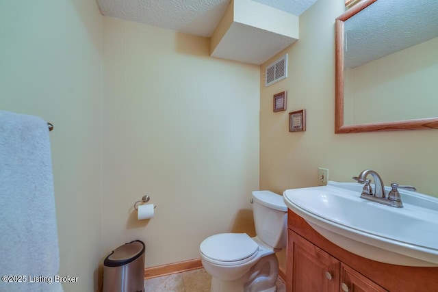 half bath featuring visible vents, vanity, toilet, a textured ceiling, and tile patterned floors