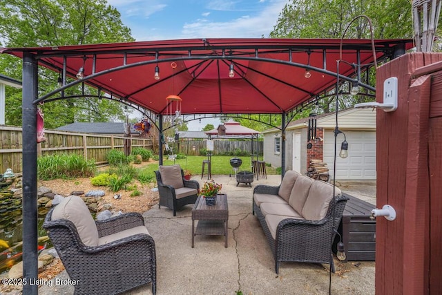view of patio / terrace with a gazebo, outdoor lounge area, an outbuilding, and a fenced backyard