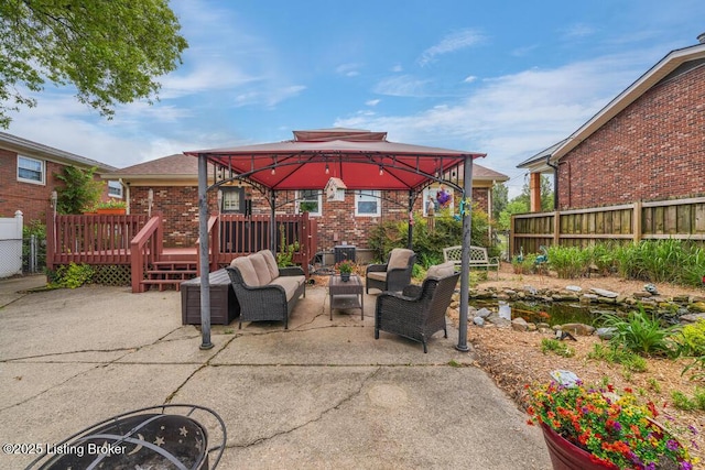 view of patio / terrace featuring a gazebo, fence, a wooden deck, and an outdoor hangout area