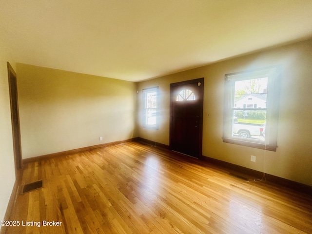 entrance foyer with a wealth of natural light, visible vents, light wood-type flooring, and baseboards