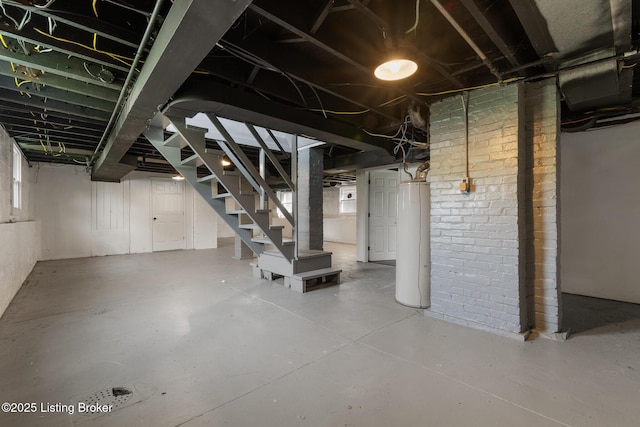 basement with water heater and stairway