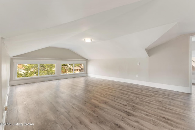bonus room featuring baseboards, wood finished floors, and lofted ceiling