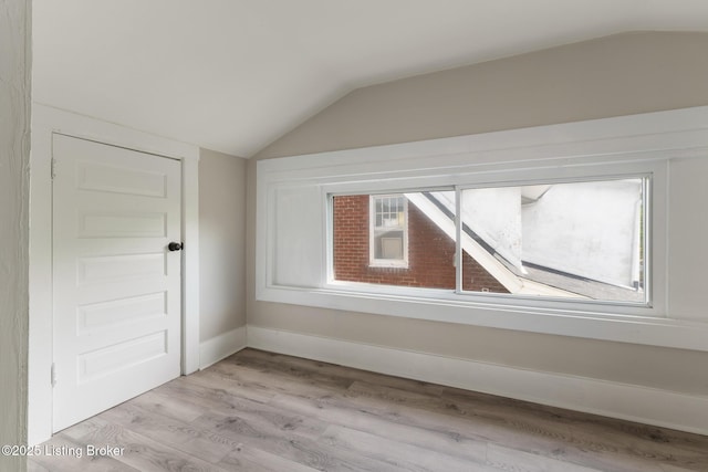 bonus room featuring lofted ceiling and light wood-type flooring
