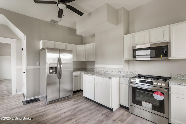 kitchen featuring light wood-style floors, appliances with stainless steel finishes, ceiling fan, white cabinetry, and visible vents