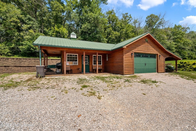 515 Brier Creek Meadows Rd, Mammoth Cave, KY 42259 - view of front of house with a garage, driveway, faux log siding, a porch, and metal roof