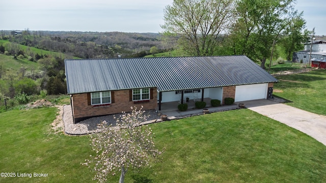single story home featuring driveway, metal roof, brick siding, a front lawn, and an attached garage