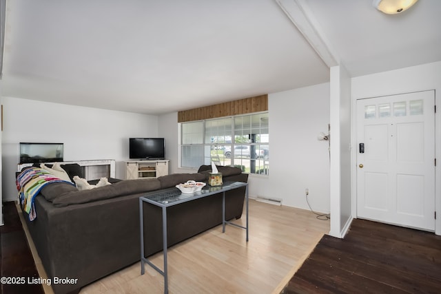 living area with visible vents and wood finished floors