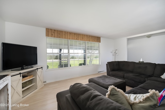 living room featuring baseboards, light wood-style flooring, and visible vents