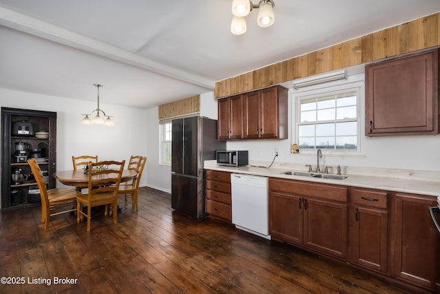 kitchen with appliances with stainless steel finishes, a sink, light countertops, a chandelier, and plenty of natural light