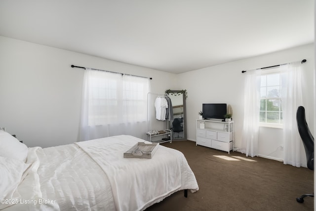 bedroom with baseboards and dark carpet