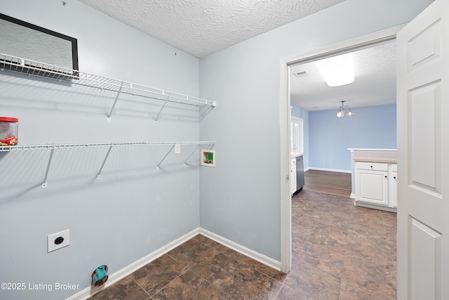 clothes washing area with hookup for an electric dryer, baseboards, hookup for a washing machine, a notable chandelier, and laundry area