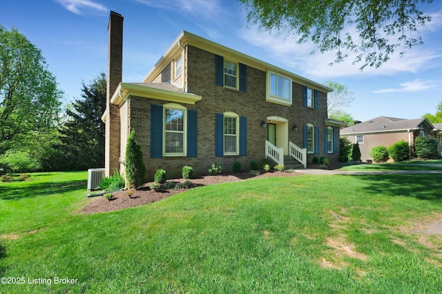 colonial inspired home with a front lawn, central AC, brick siding, and a chimney