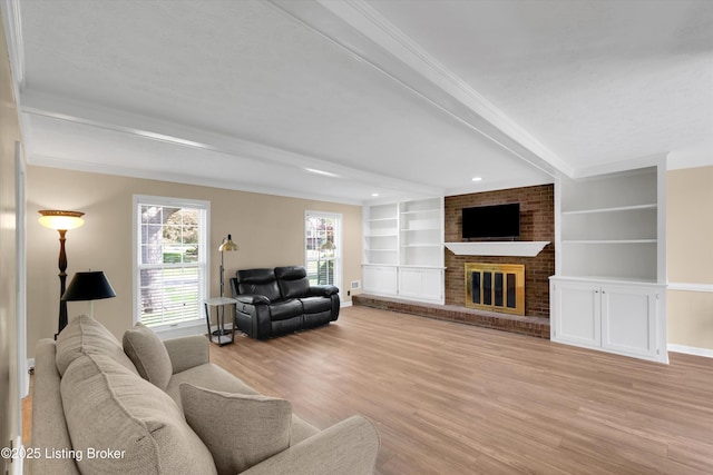living room featuring light wood-style flooring, beamed ceiling, baseboards, a brick fireplace, and built in features