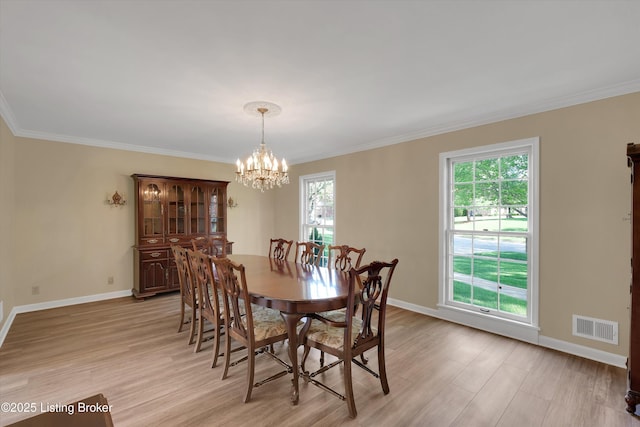 dining space featuring an inviting chandelier, visible vents, light wood finished floors, and baseboards