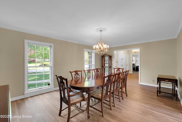 dining space featuring an inviting chandelier, crown molding, light wood-style flooring, and baseboards