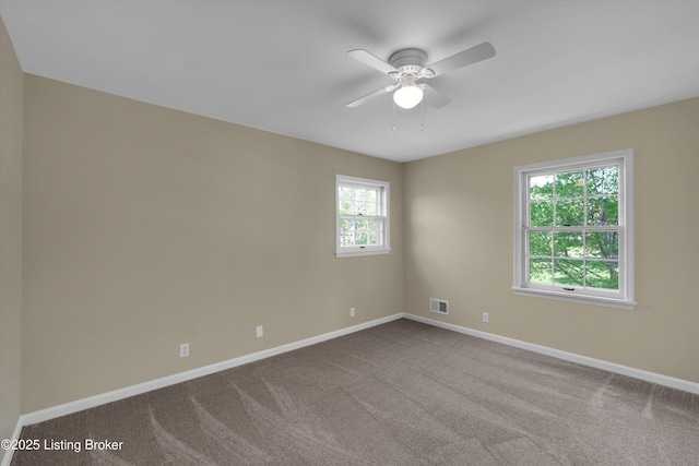 carpeted empty room with visible vents, a ceiling fan, and baseboards