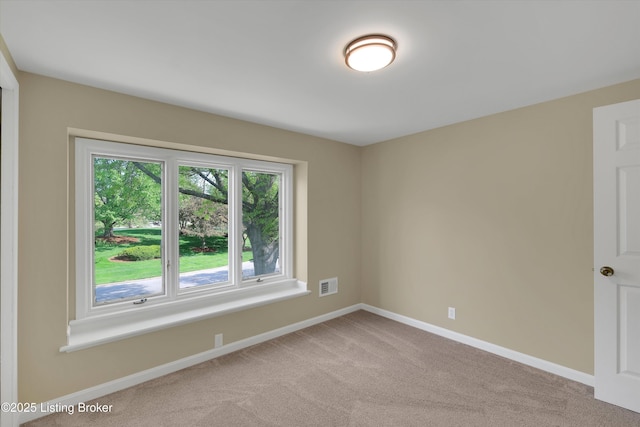 carpeted spare room with baseboards and visible vents