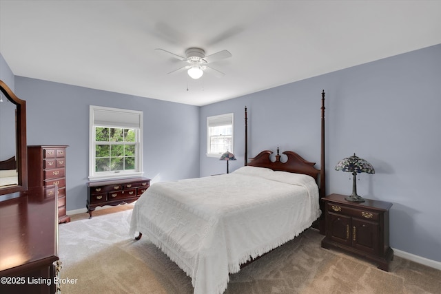 carpeted bedroom featuring ceiling fan, baseboards, and multiple windows