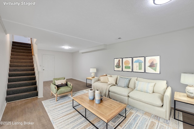 living area with baseboards, stairway, wood finished floors, and visible vents