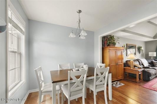dining area with wood finished floors and a notable chandelier