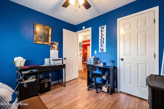 home office with a textured ceiling, ceiling fan, and wood finished floors