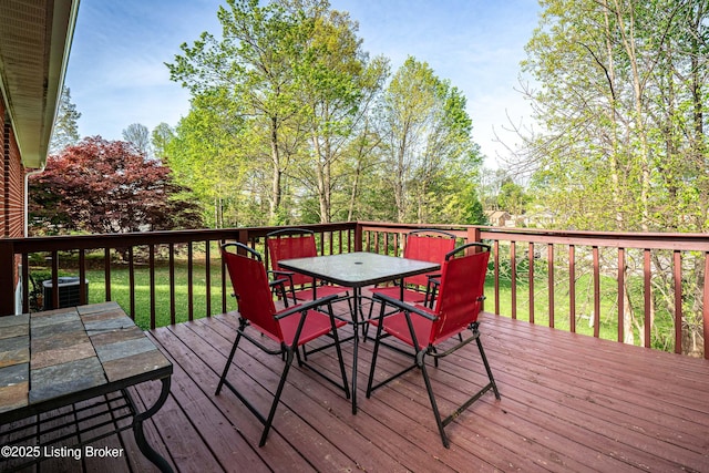 wooden deck with outdoor dining space and cooling unit