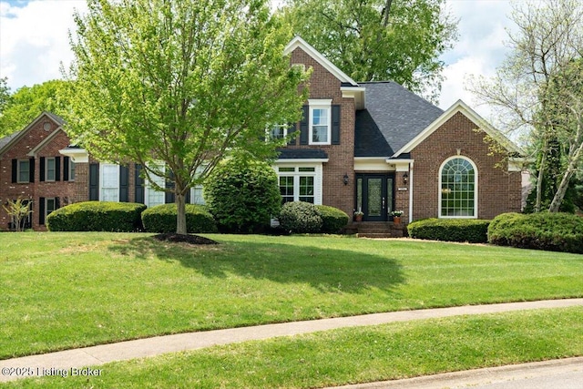 view of front of property featuring a front lawn and brick siding