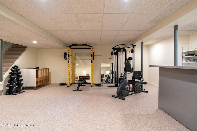 exercise area with carpet, a paneled ceiling, and baseboards