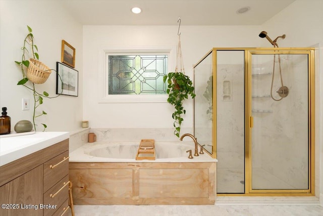 bathroom featuring a garden tub, vanity, and a marble finish shower