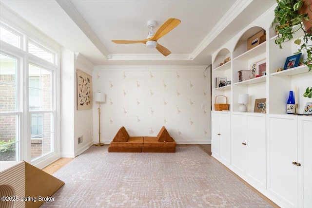 unfurnished room featuring baseboards, a ceiling fan, light wood finished floors, and crown molding