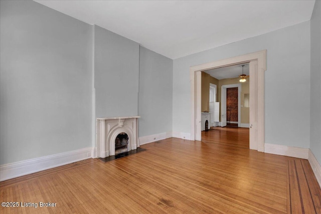 1460 S 6th St, Louisville, KY 40208 - unfurnished living room featuring baseboards, a ceiling fan, light wood-style floors, and a fireplace