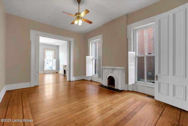1460 S 6th St, Louisville, KY 40208 - unfurnished living room with light wood-style flooring, ceiling fan, visible vents, baseboards, and a fireplace
