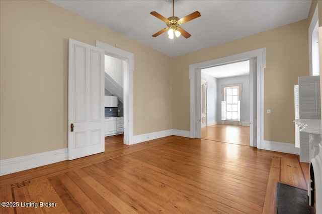 1460 S 6th St, Louisville, KY 40208 - unfurnished living room featuring baseboards, a ceiling fan, and light wood-style flooring