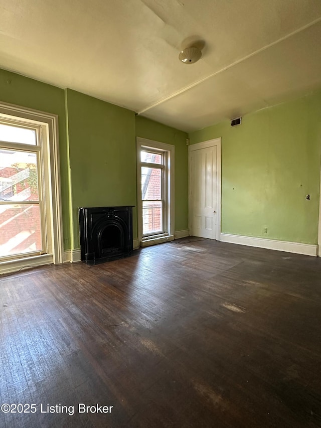 1460 S 6th St, Louisville, KY 40208 - unfurnished living room featuring visible vents, a wood stove, dark wood finished floors, and baseboards