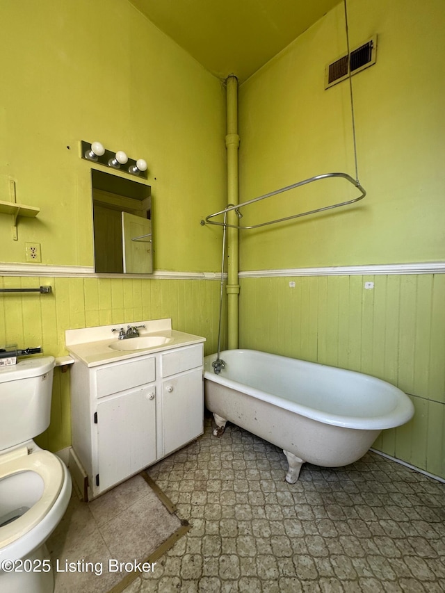 1460 S 6th St, Louisville, KY 40208 - bathroom featuring vanity, toilet, a wainscoted wall, a freestanding bath, and visible vents