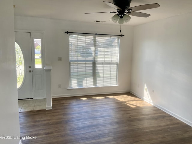 foyer entrance with a ceiling fan, visible vents, wood finished floors, and baseboards