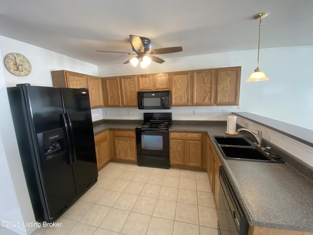 kitchen featuring black appliances, dark countertops, and a sink