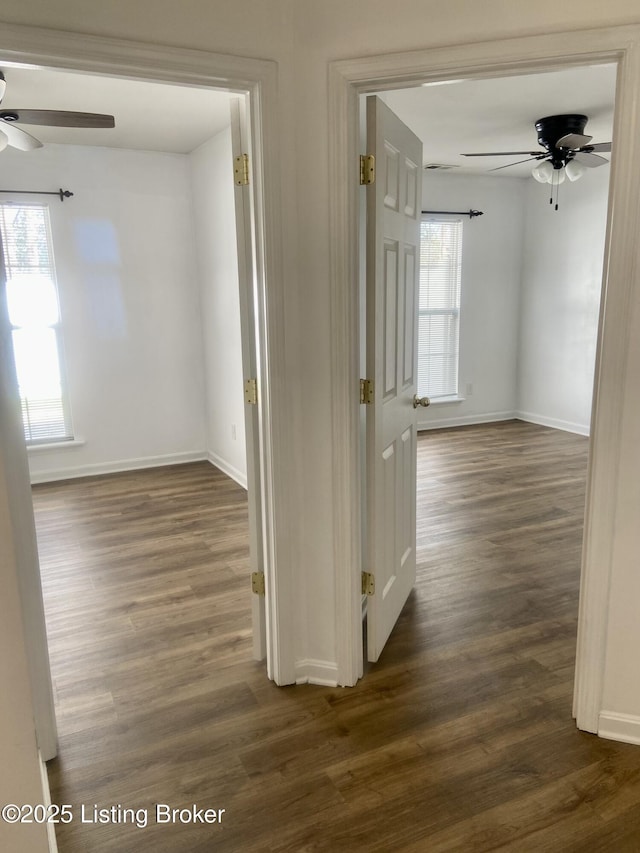 hallway with baseboards and dark wood-style flooring