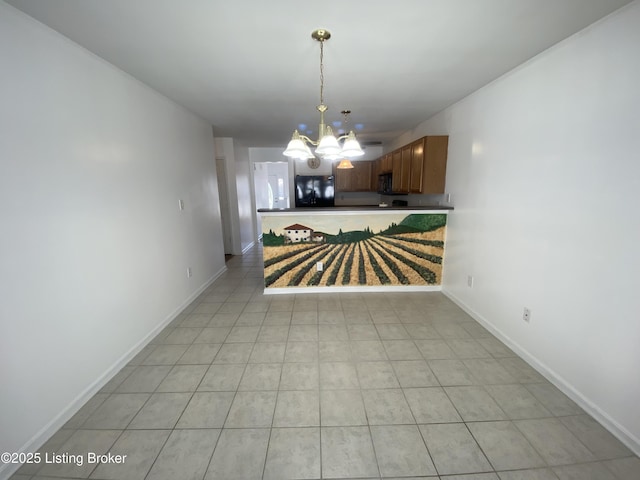 unfurnished dining area featuring a chandelier and baseboards
