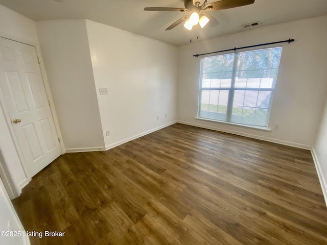 empty room with visible vents, ceiling fan, wood finished floors, and baseboards