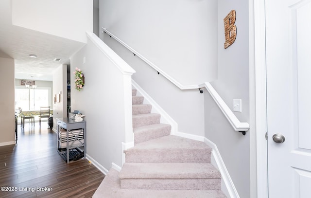 stairs featuring wood finished floors and baseboards
