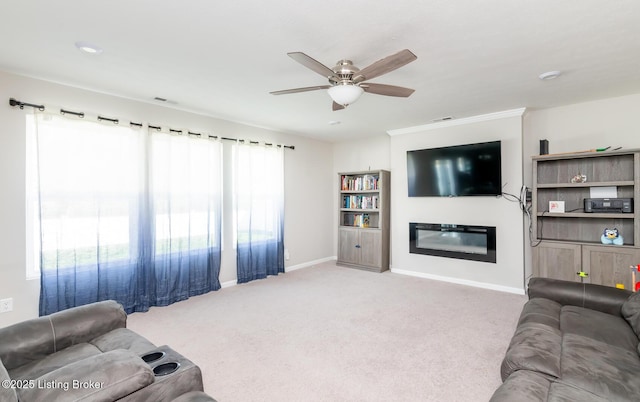carpeted living area featuring a glass covered fireplace, ceiling fan, visible vents, and baseboards