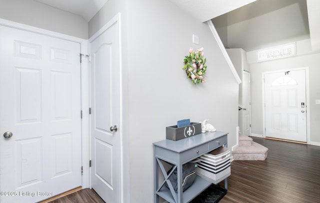 entrance foyer with stairs, baseboards, and dark wood-type flooring