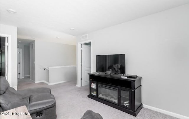 living area featuring baseboards, visible vents, and carpet flooring