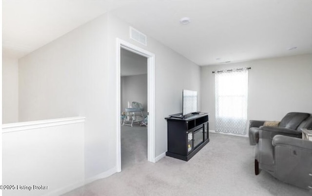 living area with baseboards, visible vents, and carpet flooring