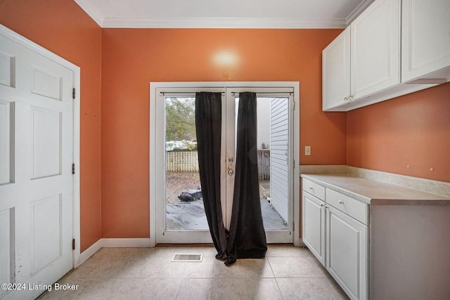 doorway featuring ornamental molding, light tile patterned flooring, visible vents, and baseboards