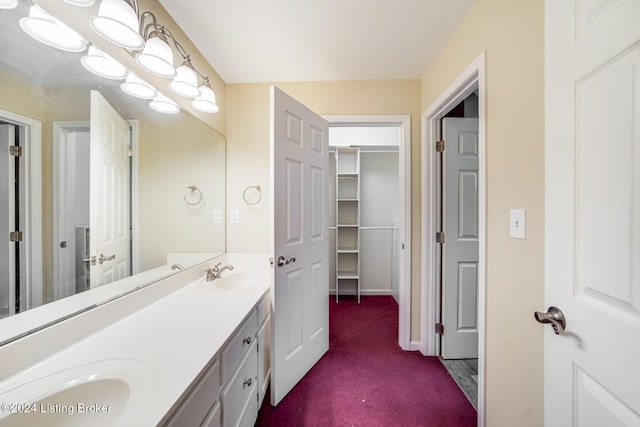 full bathroom featuring double vanity, a sink, and baseboards